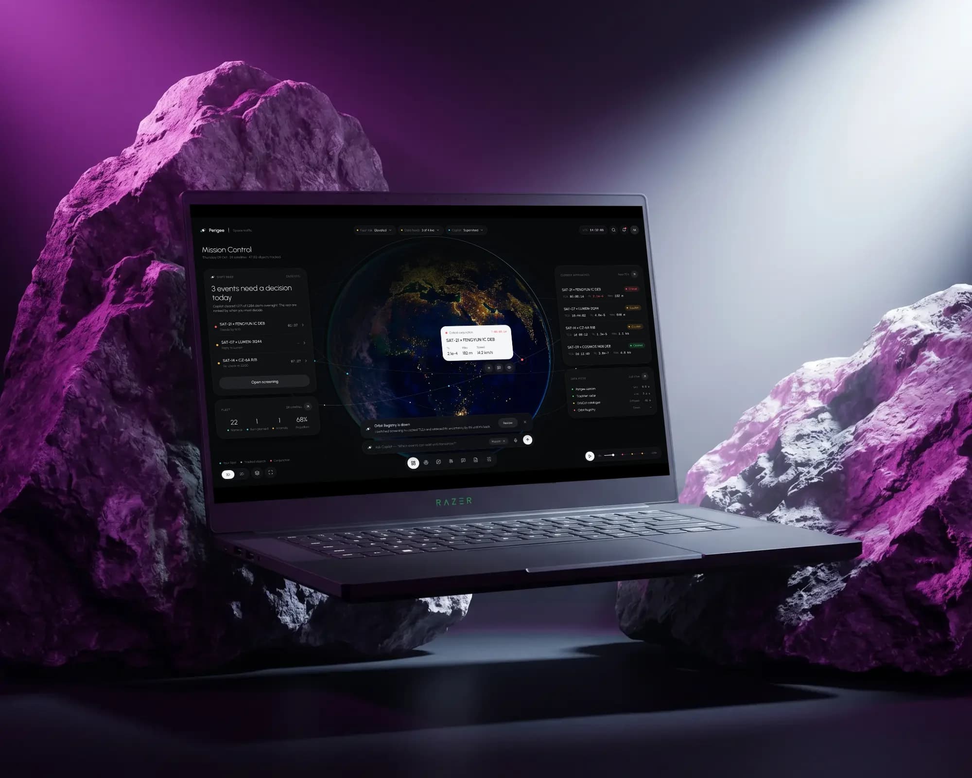 Perigee Mission Control on a laptop between two violet-lit rocks, a beam of light across a dark stage